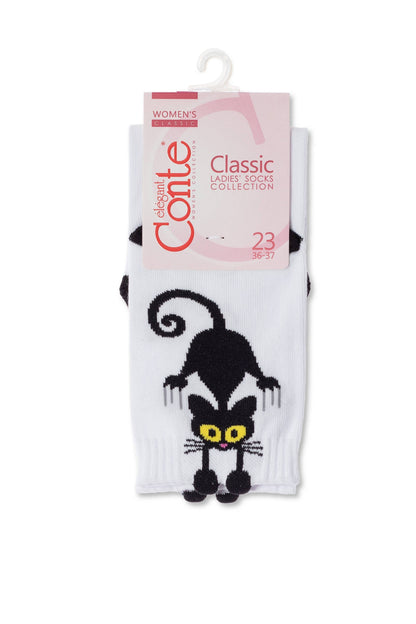 A pair of white ankle socks features a stylized black cat design with large yellow eyes and a small pink tongue on the front.