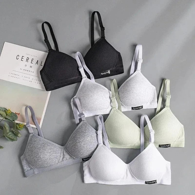 A flat lay of six ribbed triangle bralettes featuring adjustable straps and a small rectangular tag labeled Sports belt, arranged in black, white, grey, and light green on a grey background.