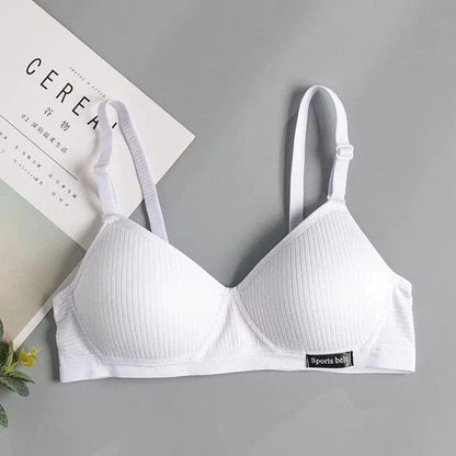 A white ribbed wireless bralette with adjustable straps and a small black rectangular tag labeled Sports belt on the bottom right band.