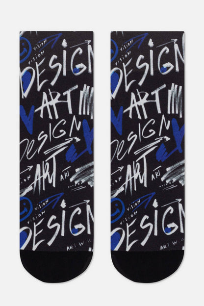 A pair of black crew socks featuring a repeating graffiti-style print with the words DESIGN and ART in white and blue, accented by abstract strokes and small smiley face symbols.