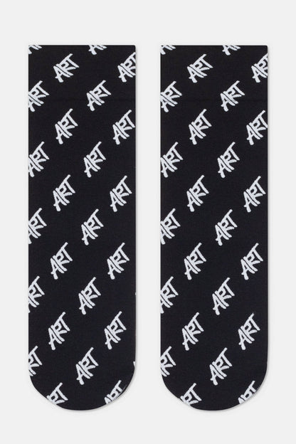 A pair of black crew socks featuring a repeating white diagonal pattern of the word ART in a handwritten style font.