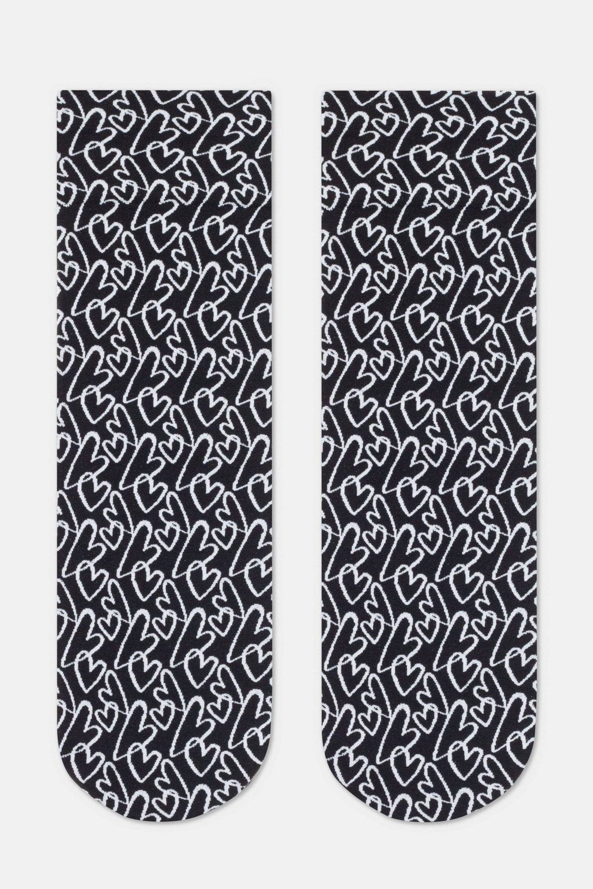 A pair of crew-length socks in black with an all-over repeating pattern of white hand-drawn heart outlines.