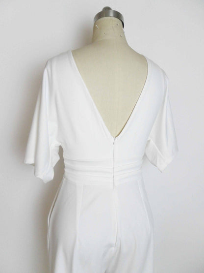 A white V-neck jumpsuit with flutter sleeves and a cinched waist displayed on a dress form against a plain white background.