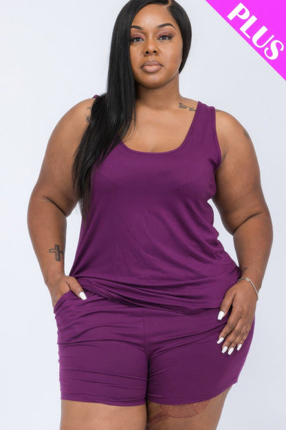 A plus size model wears a plum purple matching tank top and shorts set against a plain white background.
