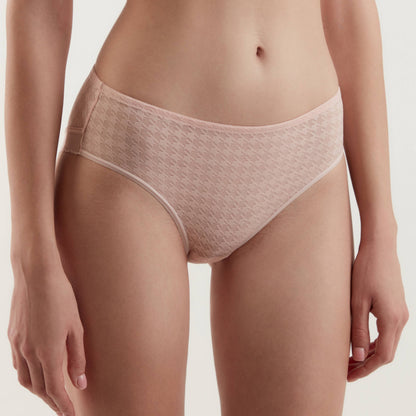 A pair of light pink, low-rise bikini briefs with a subtle houndstooth texture, worn by a person against a neutral background.