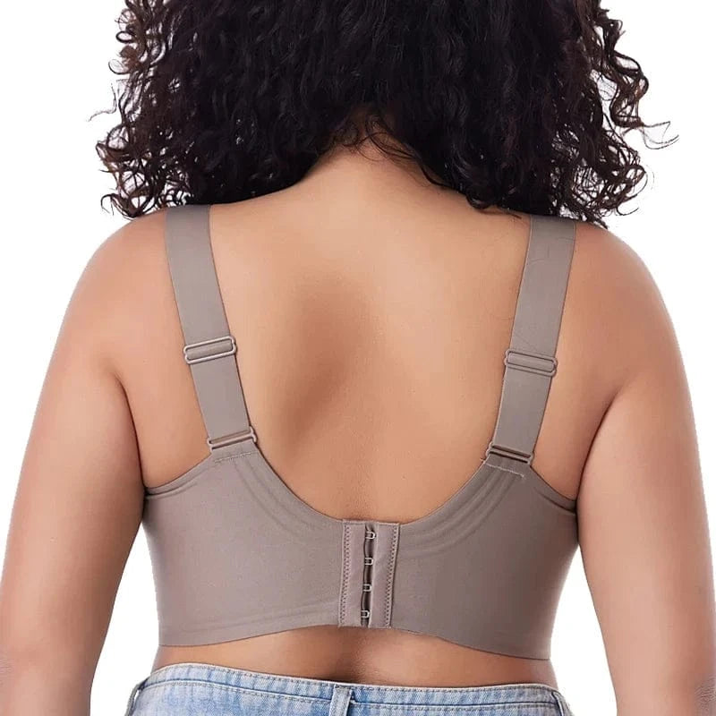 A beige full-coverage bra viewed from the back, featuring wide adjustable straps and a hook-and-eye closure against a plain white background.