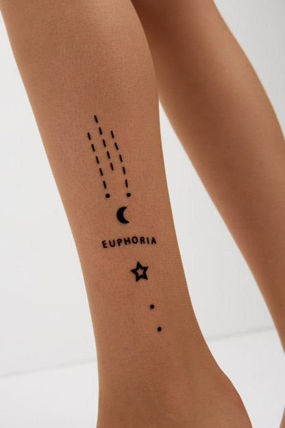 A close-up view of a leg wearing sheer tan tights featuring a black celestial-themed temporary tattoo design consisting of a crescent moon, stars, dots, and the word euphoria.