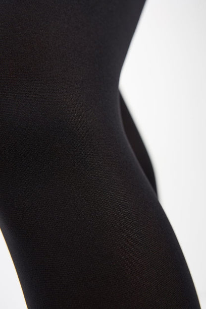 A close-up view of black opaque fabric showing the fine, textured knit detail.