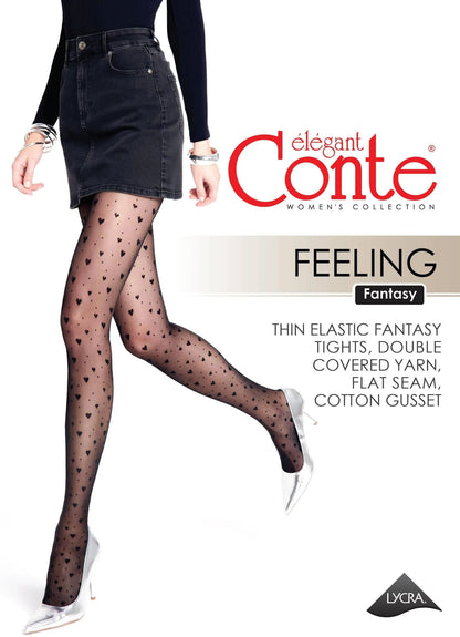 A model wearing black sheer tights patterned with small dark hearts, styled with a black denim mini skirt and silver high-heeled pumps.