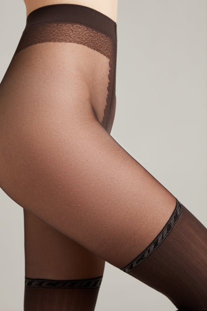 A close-up side view of sheer dark brown pantyhose featuring a patterned waistband and a decorative band with repeating text details above the knee.