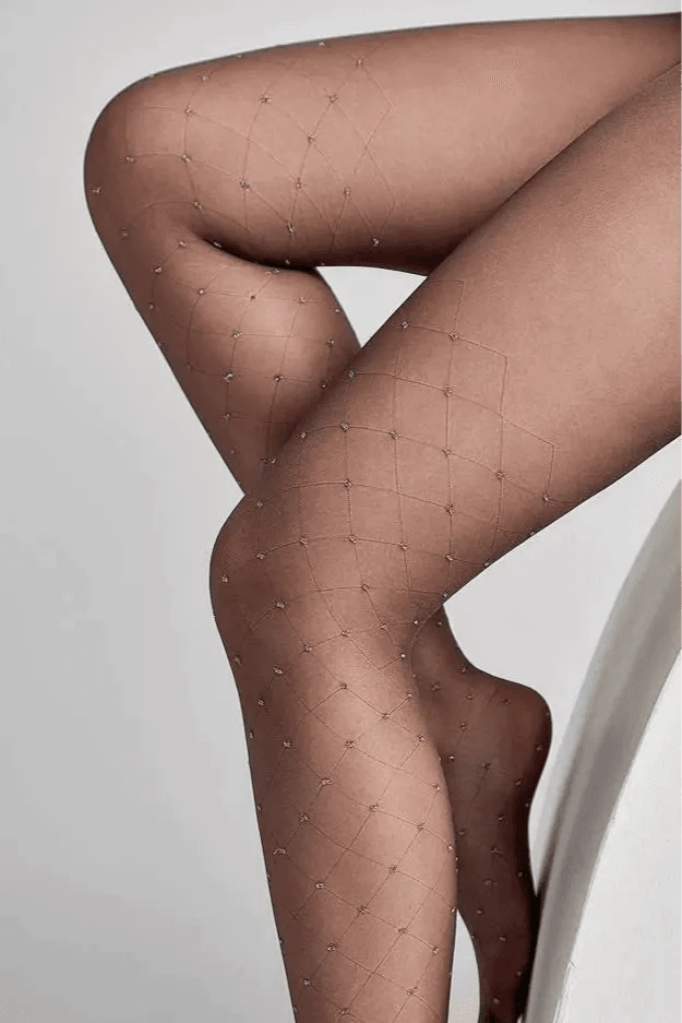 Sheer black tights feature a subtle diamond grid pattern adorned with tiny, shimmering silver accents at each intersection, modeled on legs.