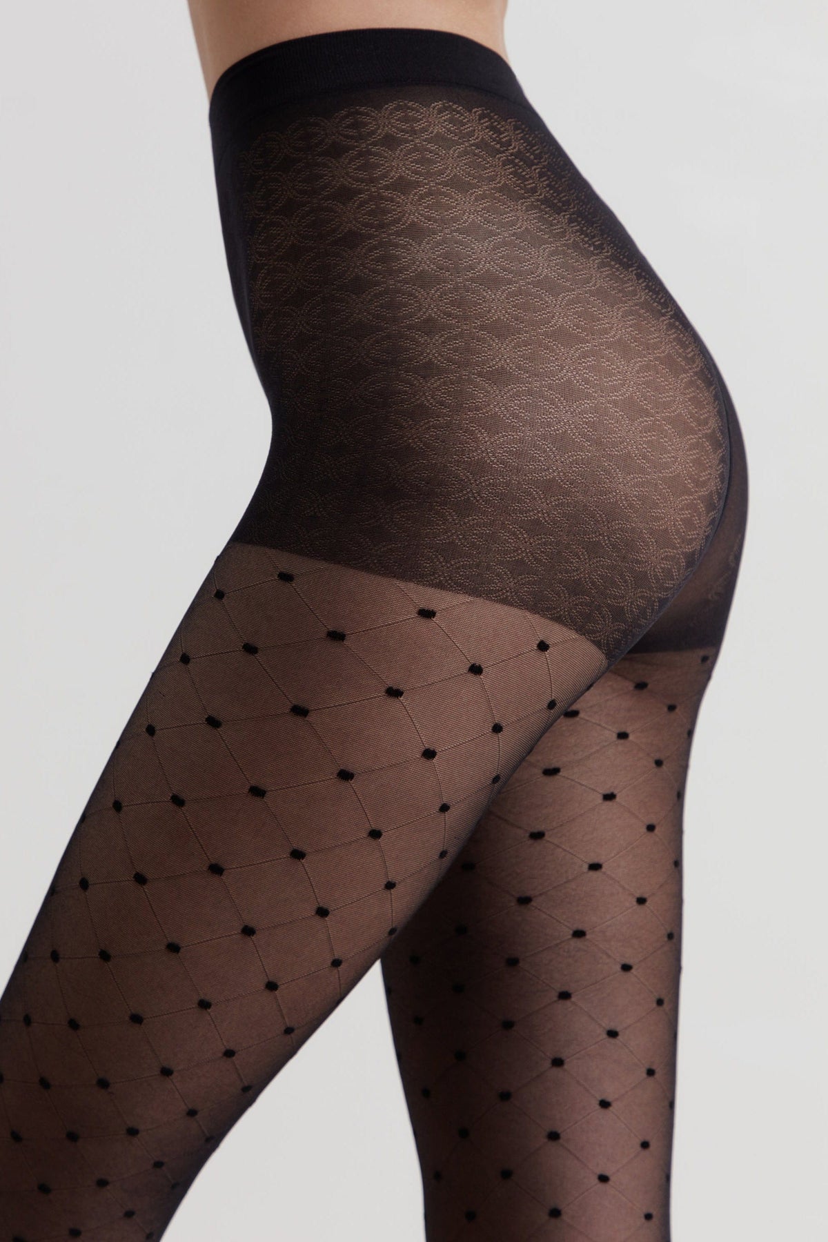 Black sheer tights featuring a patterned high-waist band and a diamond grid design with small raised dots throughout the legs.