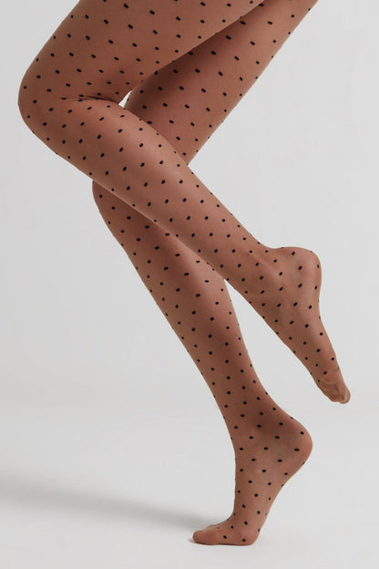 Sheer tan-colored tights featuring a pattern of small, evenly spaced black dots worn on legs posed against a solid white background.