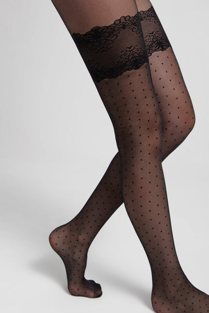Black sheer polka dot tights featuring an intricate floral lace garter-style band at the top, modeled on a pair of legs.