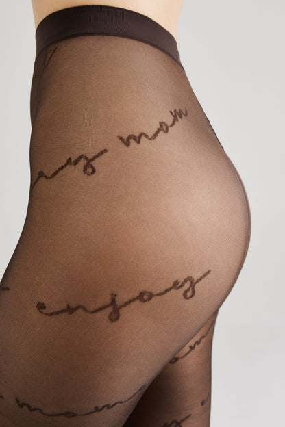 A close-up side profile of a person wearing sheer brown tights patterned with repeating cursive script text.