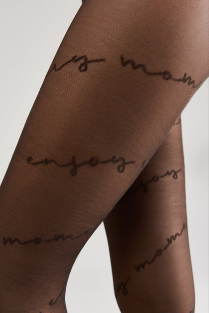 Sheer black pantyhose patterned with the repeating handwritten-style text enjoy moments in a dark brown script.