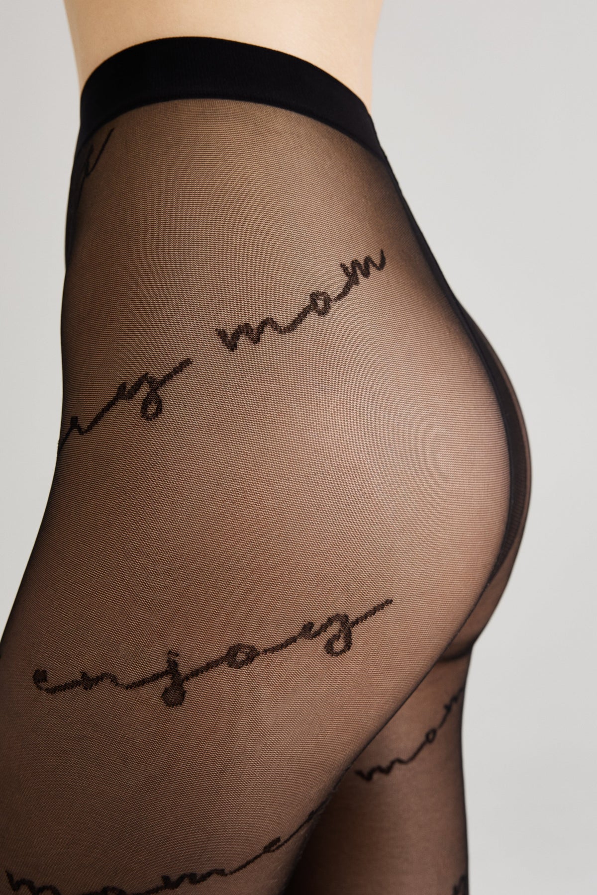Black sheer pantyhose featuring a repeating script text pattern on the leg.