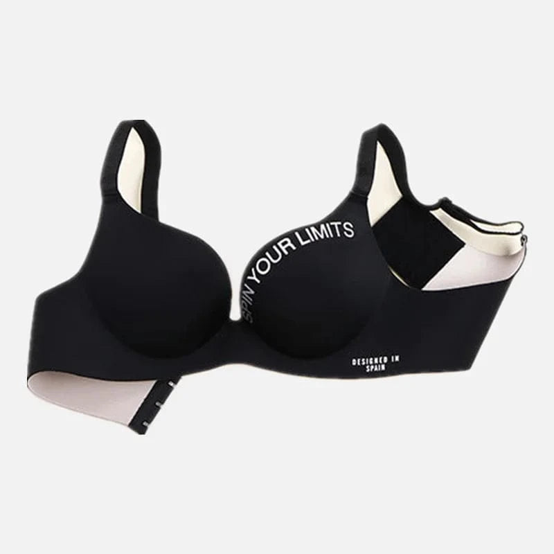A black padded sports bra featuring the white text SPIN YOUR LIMITS along the top of the cup and DESIGNED IN SPAIN near the bottom band, displayed against a plain white background.