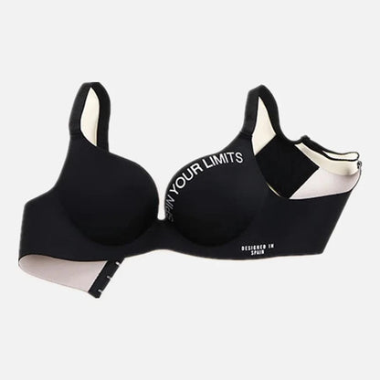 A black padded sports bra featuring the white text SPIN YOUR LIMITS along the top of the cup and DESIGNED IN SPAIN near the bottom band, displayed against a plain white background.