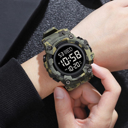 A camouflage-patterned digital sports watch is worn on a wrist, featuring a round black dial with a digital display showing the time, date, and day of the week.