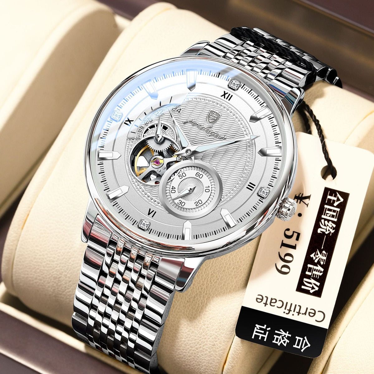 A silver-toned analog wristwatch with a metallic link band and a textured white dial featuring a visible internal gear movement and a small secondary clock face, presented on a cushioned display.
