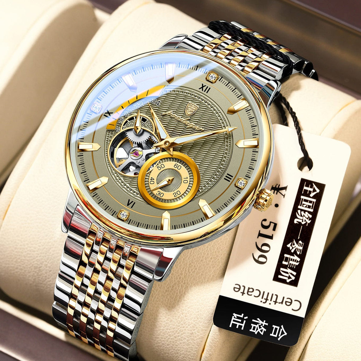 A round wristwatch with a gold and silver metallic band, featuring a pale green textured dial, a small sub-dial, and an exposed mechanical movement, presented on a beige watch cushion with an attached tag.