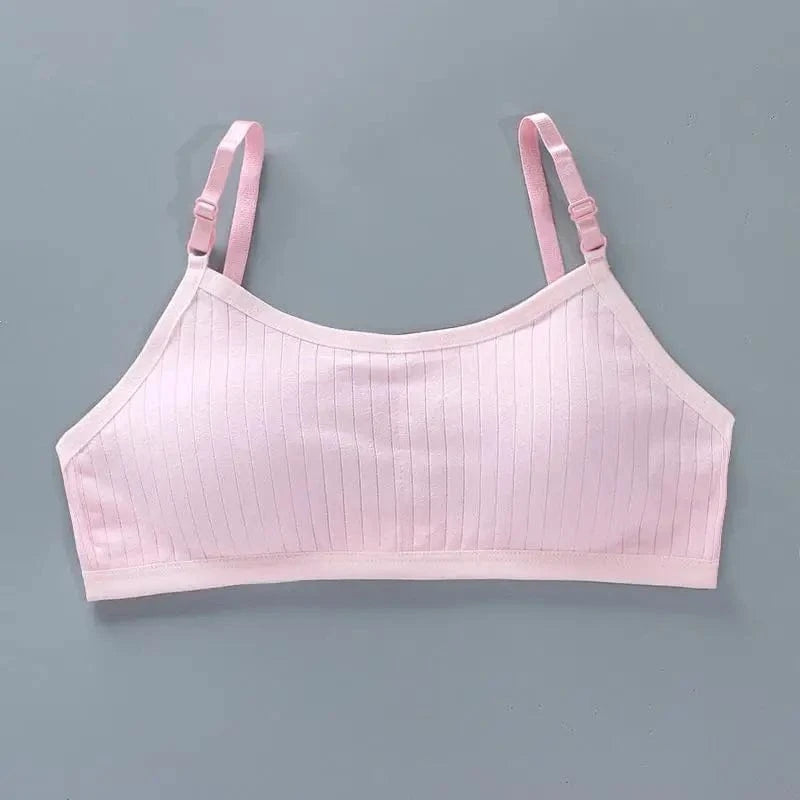 A light pink, ribbed camisole-style crop top with thin, adjustable shoulder straps, displayed flat against a plain grey background.
