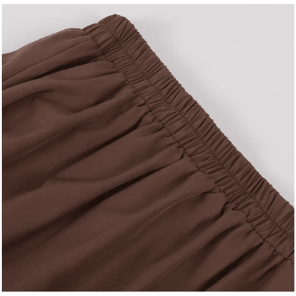 A close-up view of the brown elasticized waistband on a garment, showing the gathered fabric texture.