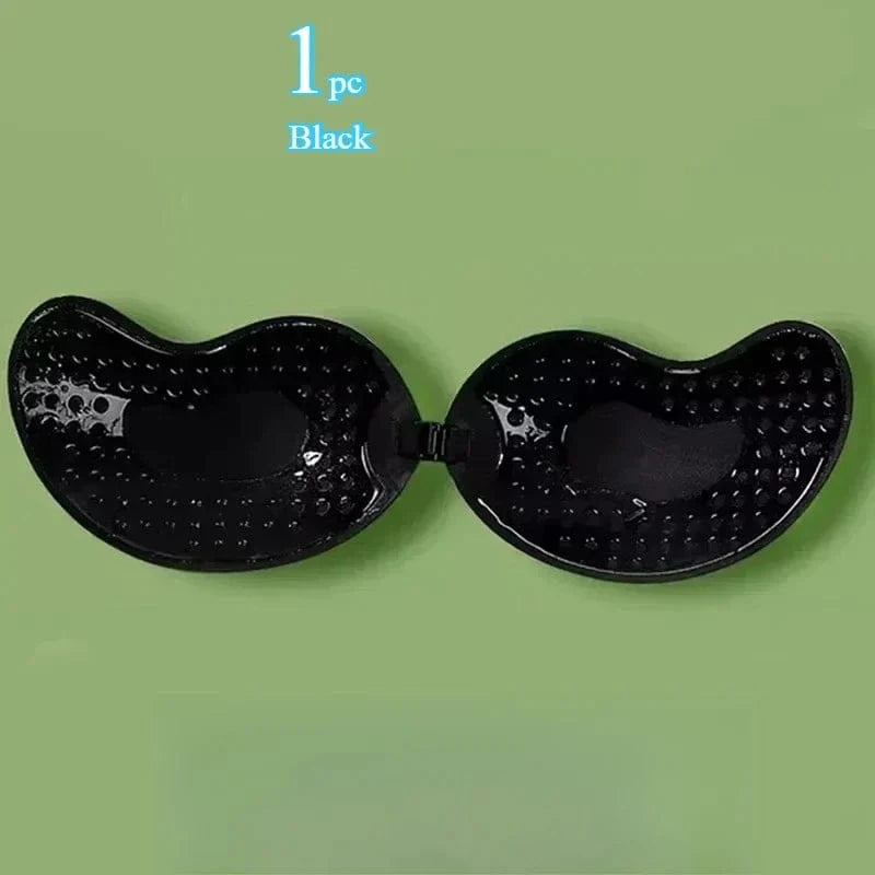 A black strapless adhesive bra with a dimpled texture on the interior surface, displayed against a light green background.