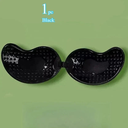A black strapless adhesive bra with a dimpled texture on the interior surface, displayed against a light green background.