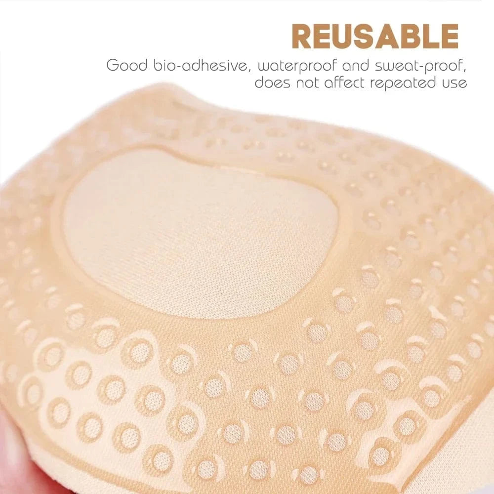 A beige, circular, adhesive silicone bra pad with a smooth center and a textured, perforated border.