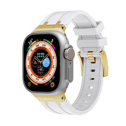 A smartwatch with a square silver casing and a colorful digital face, attached to a white silicone strap with gold metal connectors and a gold buckle.