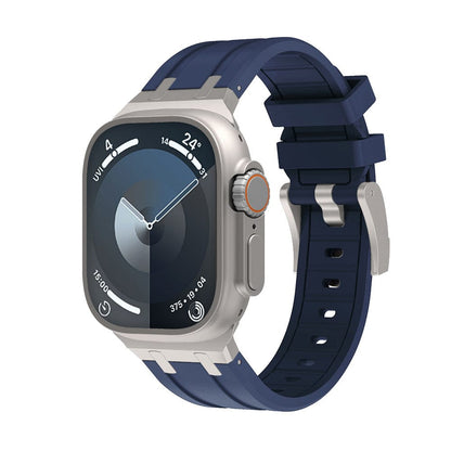 A smartwatch with a rectangular silver case, a dark blue silicone watch band, and a digital watch face displaying circular complications.