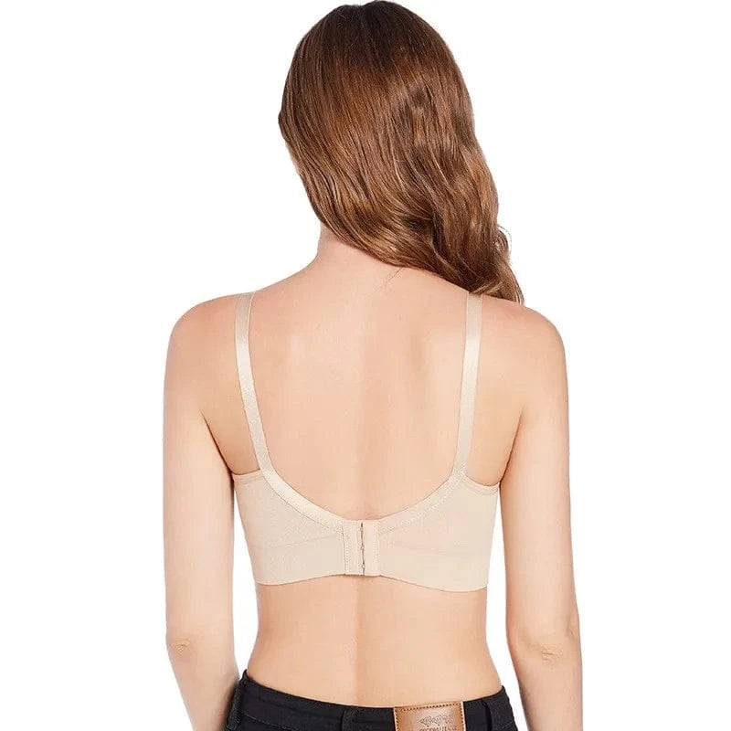 A beige bra shown from the back on a model, featuring wide shoulder straps and a center hook-and-eye closure.