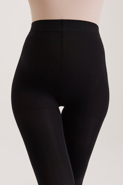 Opaque black tights worn on the lower body against a plain light background.