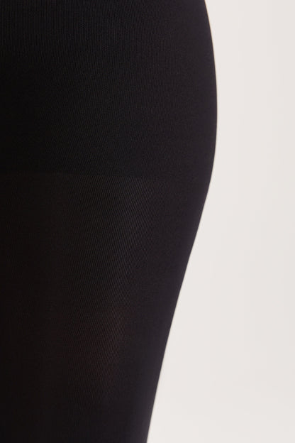 A close-up of solid black fabric, showcasing a smooth texture on the upper portion and a subtle vertical ribbing on the lower portion.