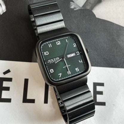 A square-faced wristwatch with a dark green dial and a black metallic link band, featuring white numbers and a day-date display at the three o'clock position.
