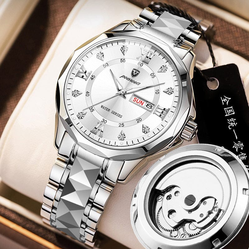 A silver-toned wristwatch featuring a white dial with diamond-shaped hour markers and a date display, displayed alongside its mechanical movement mechanism on a beige watch cushion.