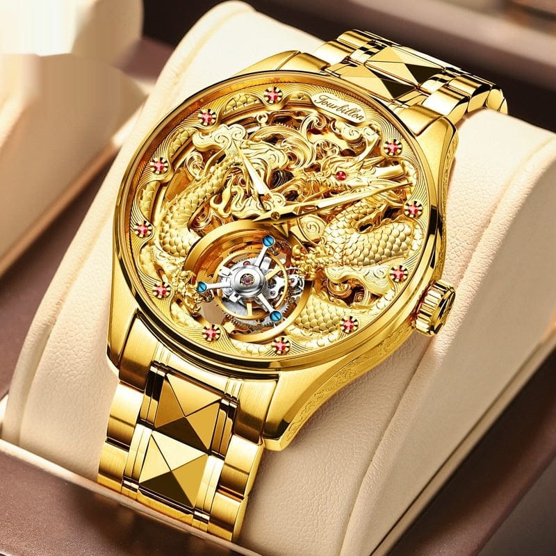 A gold-toned mechanical wristwatch featuring an intricate dragon design across the skeletonized dial and a tourbillon movement at the six o'clock position, presented on a matching gold link bracelet in a display box.
