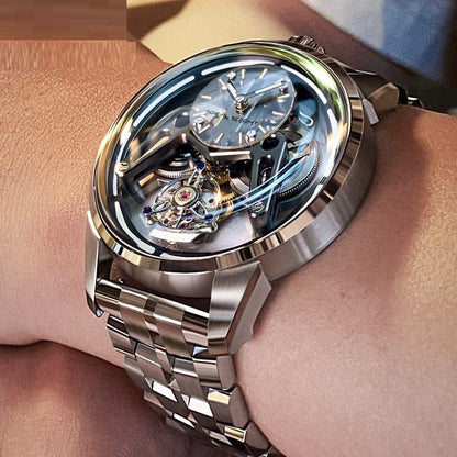 A silver-toned skeleton mechanical wristwatch with a circular metallic frame and a detailed exposed gear movement worn on a person's wrist.