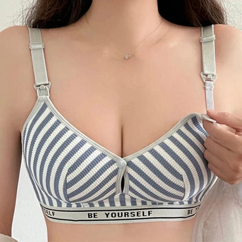 A close-up view of a blue and white striped nursing bra with adjustable straps, a front-opening clip feature, and a black elastic band labeled with the text BE YOURSELF.