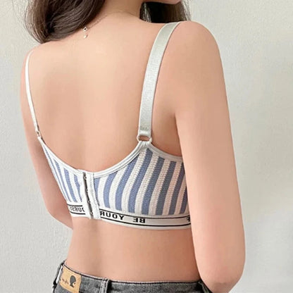 A woman seen from the back wearing a blue and white striped bralette with a front hook-and-eye closure and a black-and-white elastic band featuring text.