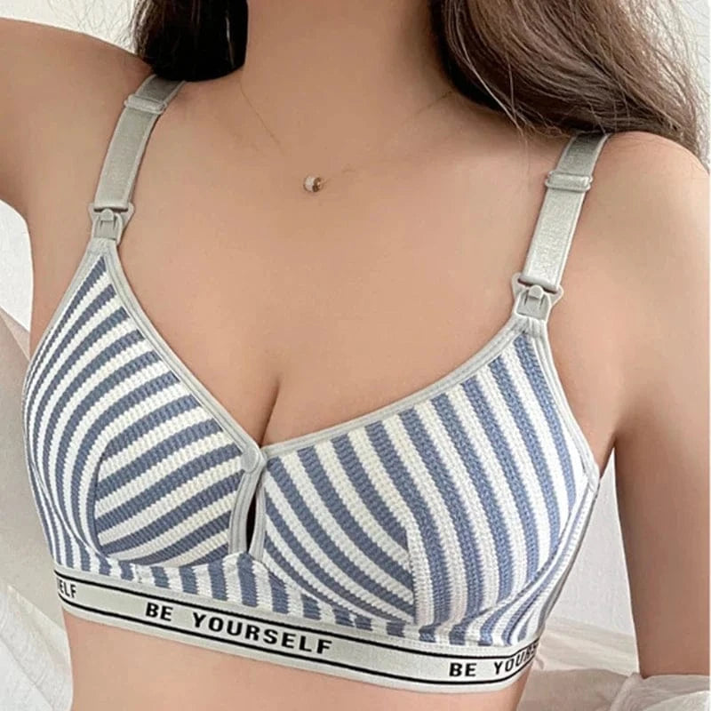 A close-up view of a blue and white striped nursing bra with adjustable straps, featuring a black and white elastic band at the bottom with the text BE YOURSELF.