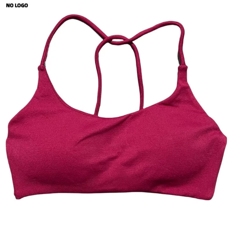 A dark pink athletic sports bra with thin, cross-back straps on a plain white background.