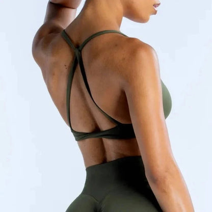 An olive green sports bra with a strappy racerback design worn by a person from behind.