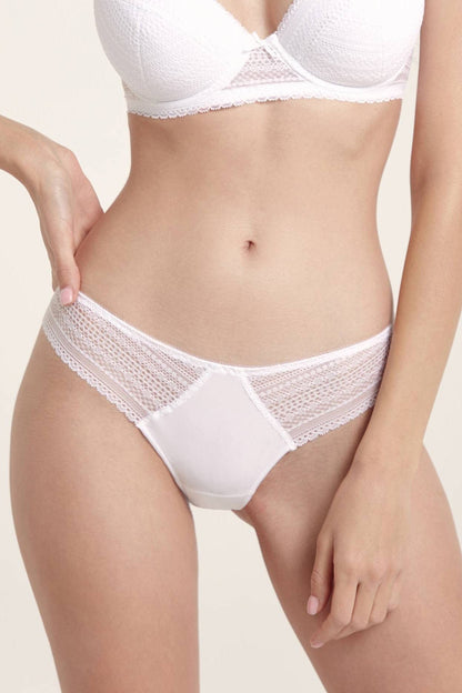 A woman wears a white lace-trimmed bikini panty and a matching white textured bra.