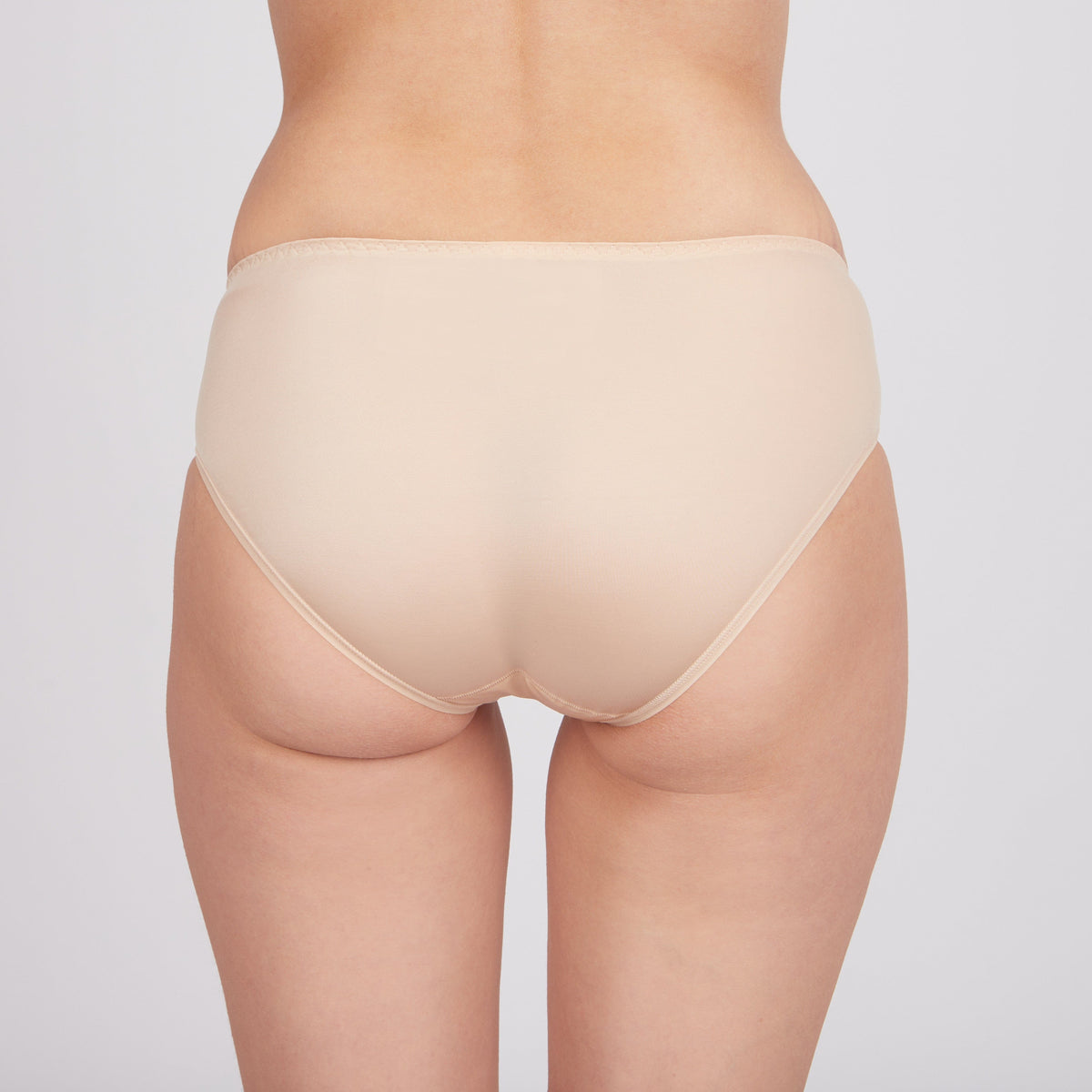 Beige women's bikini-style underwear viewed from the back against a plain light background.