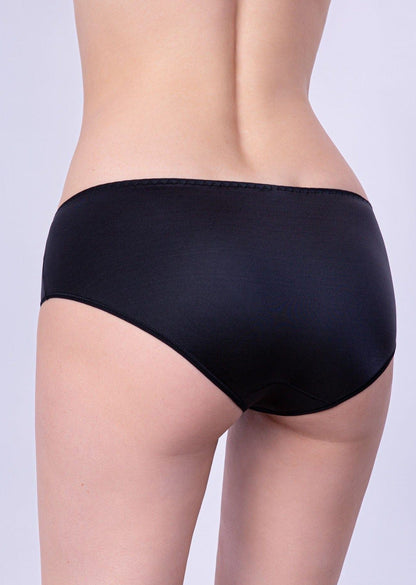 Black bikini-style panties with smooth fabric worn by a person, shown from the back view against a plain light background.