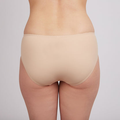Nude-colored brief panties worn from the back view, featuring a scalloped elastic waistband.