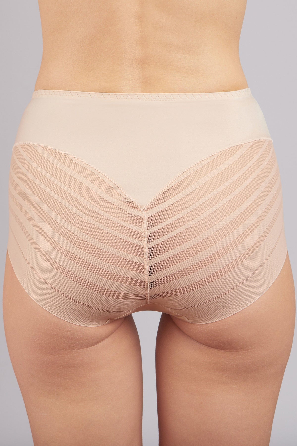 Beige high-waisted briefs with a smooth waistband and textured striped side panels worn on a model against a light gray background.
